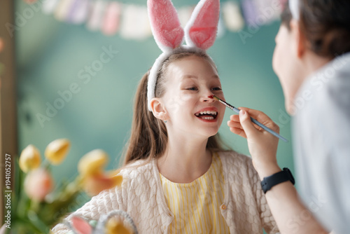 Joyful Child with Bunny Ears Having Face Painted for Easter Cele