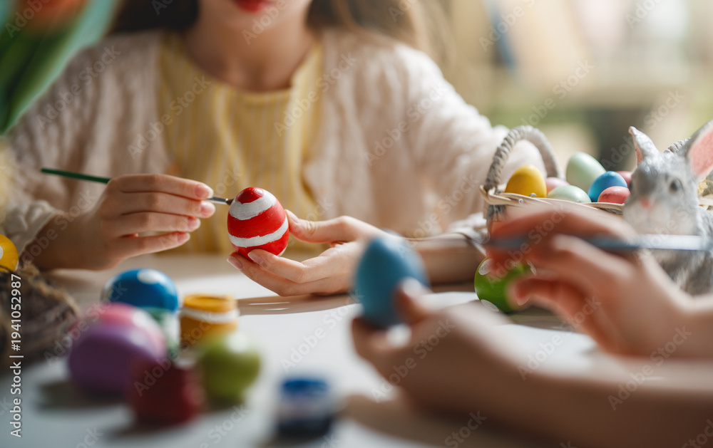 Obraz premium Close-Up of Children Painting Colorful Easter Eggs for Spring Holiday Celebration