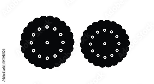 Two black circular cookies with dotted patterns isolated on a white background