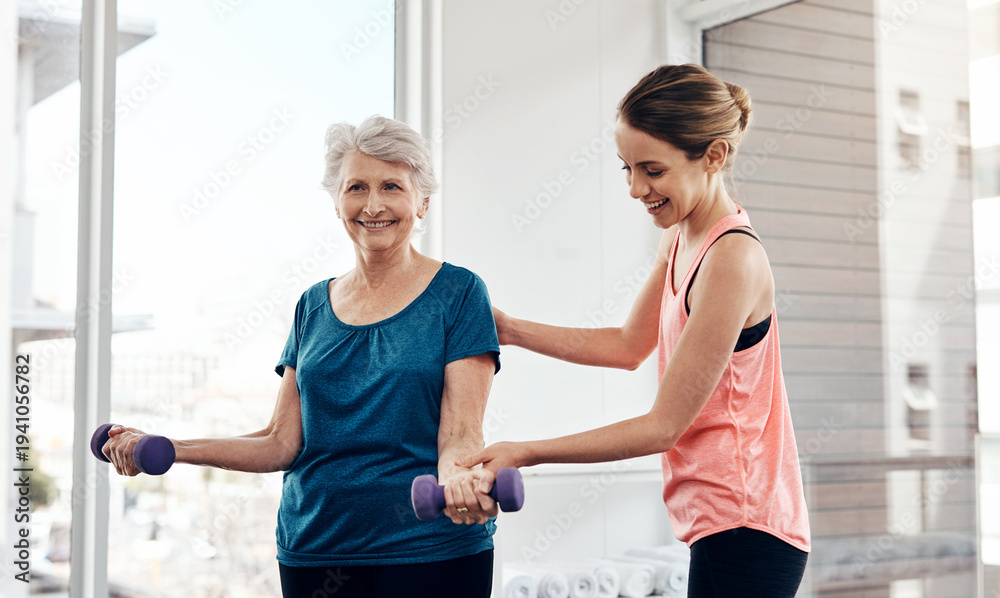 Fototapeta premium Old woman, coach and dumbbells for fitness at gym with support, weightlifting and happy in retirement. People, personal trainer and smile with exercise, workout and talk for guide at training center