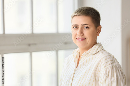 фотографія Portrait of young woman with short hair near window at home