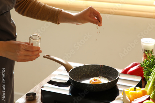 Woman adding paprika into f...