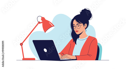 Young woman with glasses and her hair in a bun works diligently on her laptop at a desk under the light of a red desk lamp.