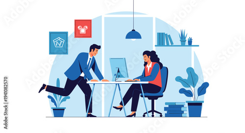 Professional scene showing a businessman leaning over a desk to talk with a female colleague who is working on a computer in an office.