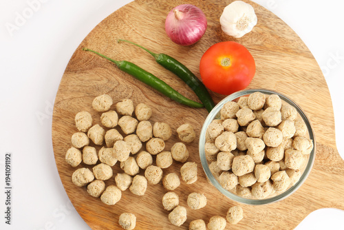Raw soya chunks ,garlic ,green chilli, onion, tomato, on cutting board . Healthy, nutritious soybean meat, chunks Vegan food concept.  known as soya wadi or meal maker in India