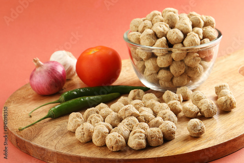 Raw soya chunks ,garlic ,green chilli, onion, tomato, on cutting board . Healthy, nutritious soybean meat, chunks Vegan food concept.  known as soya wadi or meal maker in India