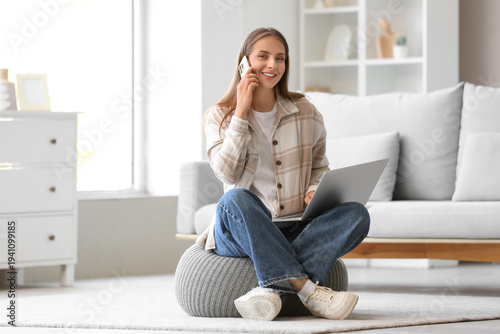 Young woman with laptop tal...