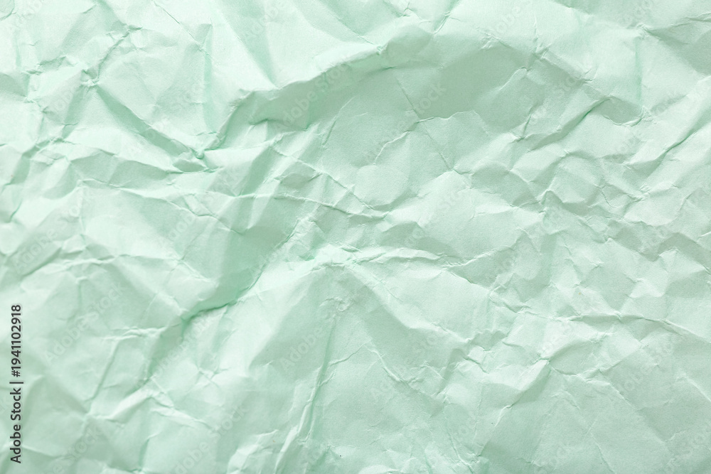 Obraz premium Green crumpled sheet of paper as background, top view