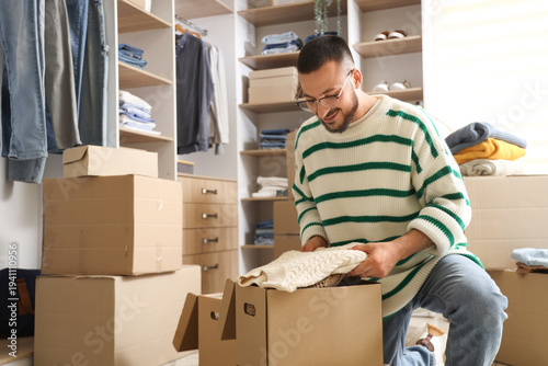Young man packing clothes i...