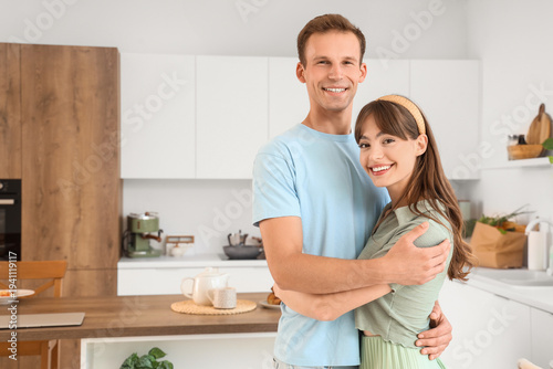 Young couple hugging in kit...