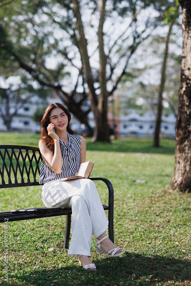 Obraz premium Young woman enjoying communicating on smartphone in park