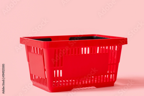 Red shopping basket on pink...
