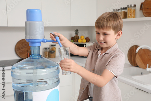 Cute little boy pouring wat...