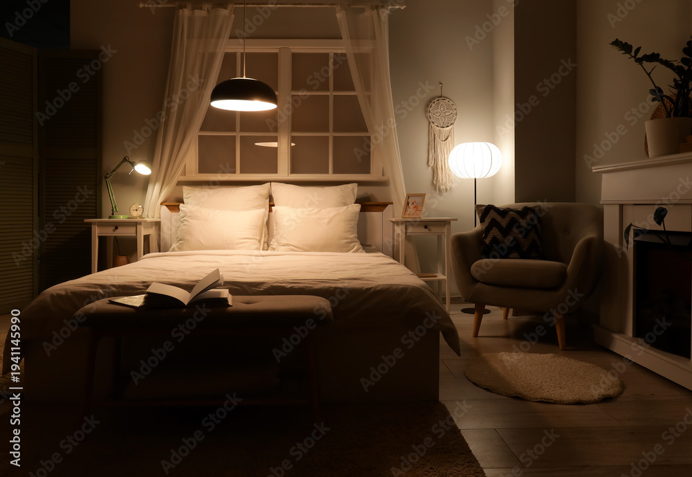 Fototapeta premium Interior of dark bedroom with armchair, fireplace and glowing lamps