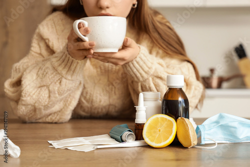 Sick woman with tea cup and...