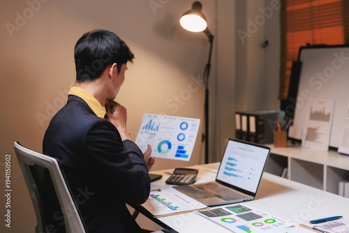 Man analyzing business data reports and financial charts