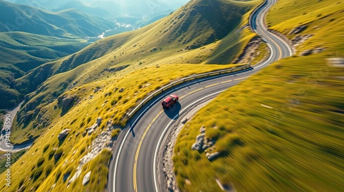 Dynamic Aerial View of Winding Mountain Road with Car, Vibrant Green Hills, Scenic Travel Adventure Landscape