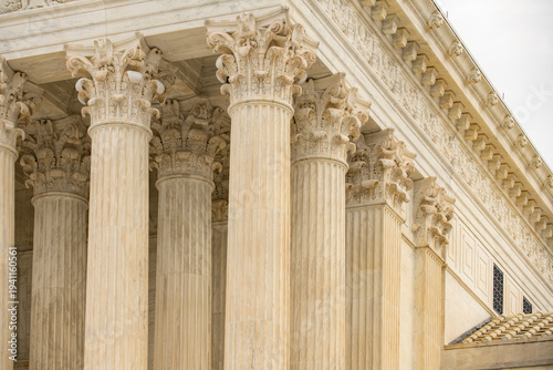 Columns marble Tall vertical facade. Columns architectural symmetry texture. Columns decorative capitals ornament Sculpture. Columns classical structure.