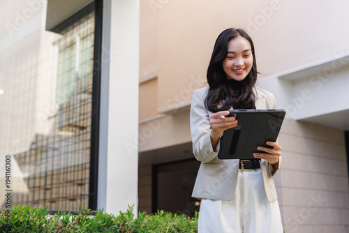 Female real estate agent using digital tablet outdoor