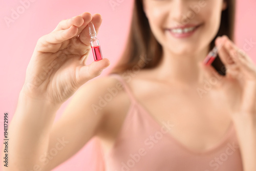 Young woman with ampules on...
