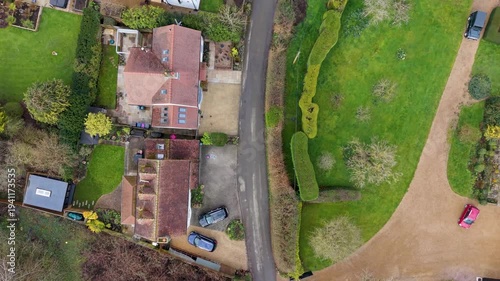 Wallpaper Mural B158 road in Chapmore End top-down drone flight following the main road as it turns forward past gardens, hedgerows and village homes, ideal for UK rural transport and travel visuals. Torontodigital.ca
