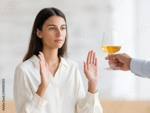 Woman gestures with hands while rejecting a drink in a bright indoor setting