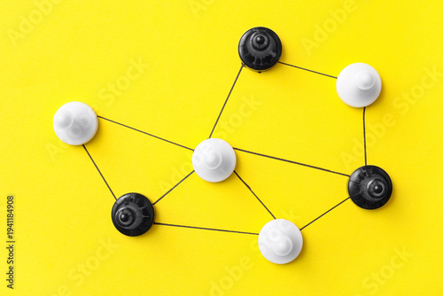 Картината върху платно Connected pawns on yellow background. Link concept