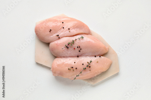 Board with raw chicken brea...