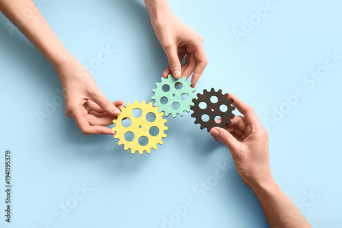 Hands holding wooden gears ...