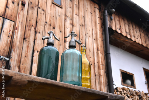Canvastavla Vintage glass soda siphons and yellow bottle on rustic wooden bench