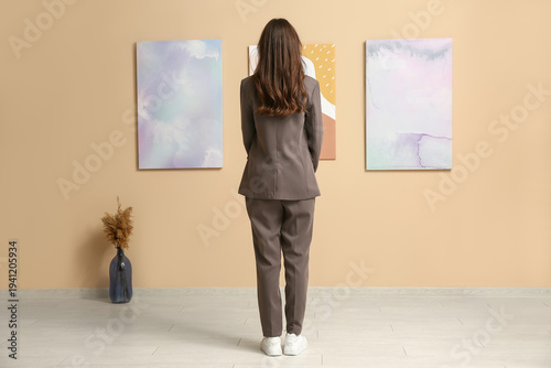 Young woman near paintings ...