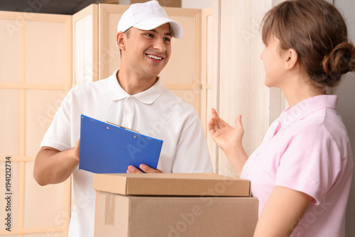 Delivery man giving parcels to woman at doorway