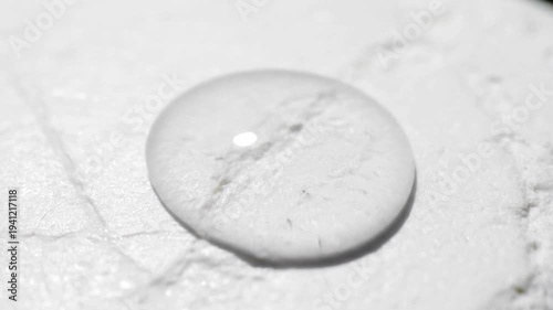 Water Droplet on White Marble Surface Closeup.
