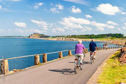 Cyclists on coastal path near a historic fortress in The swedish town Varberg