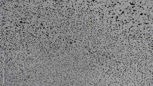 Foto Gray concrete wall texture with porous surface pattern
