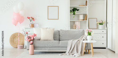 Interior of light living room decorated for Mother's Day with sofa, flowers and balloons