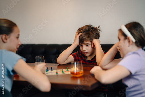 Fotografie Children playing board game feeling frustration