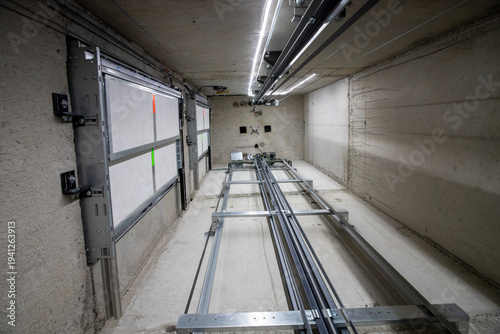 Il s'agit d'une vue intérieure d'une cage d'ascenseur avec les pièces mécaniques et le câblage essentiels lors de la rénovation d'un monte-charge. Réparation, entretien et maintenance.