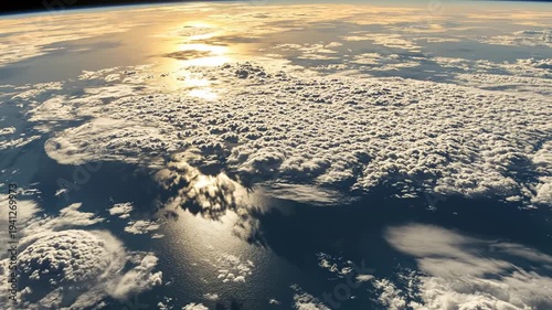 Aerial view of cloud formations over ocean reflecting sunlight, showcasing the gradual transition of light and texture across the expansive sky and water surface