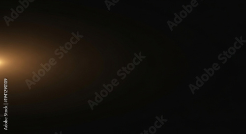 A bright yellow light shining in the dark night sky with a beam of light