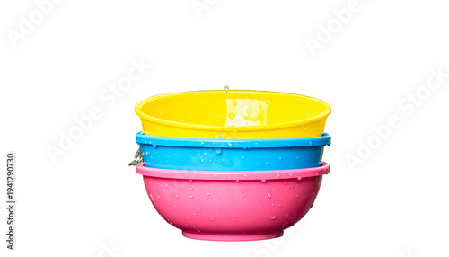 A stack of three colorful plastic bowls with water droplets against a solid black backdrop