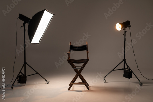 Film director chair between studio lights on professional photography set