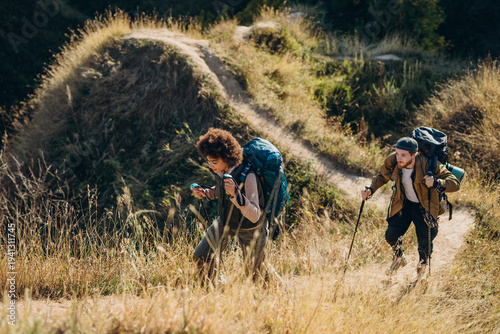 Konstfotografi Mixed race family travels together at autumn valley goes uphill leaning into Nor