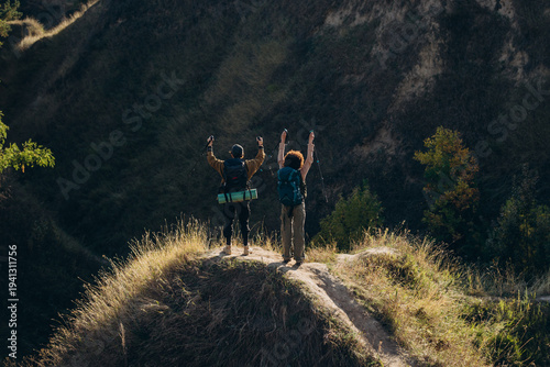 Quadro su tela Mixed race family with backpacks rest enjoying hike goal achievement in nature p
