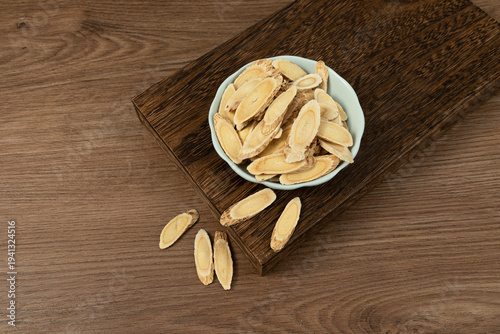 Astragalus Slices in Celadon Bowl on Wooden Table