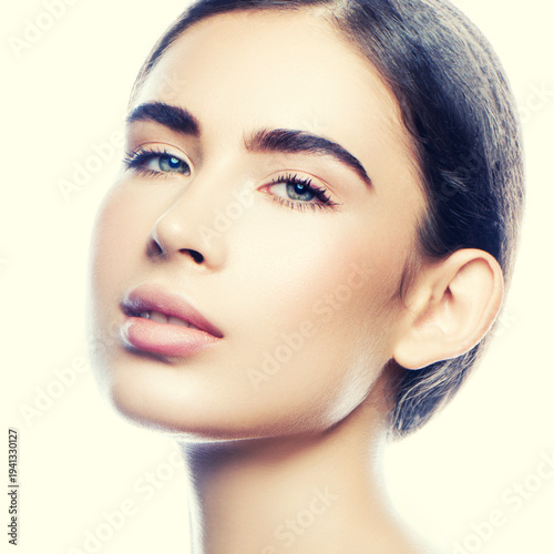 Beauty face of young caucasian model girl with natural day nude makeup, clean skin and slick hair, blue eyes. Skincare health facial treatment concept