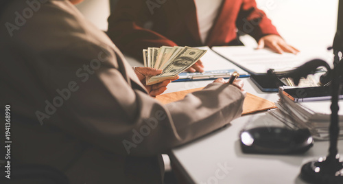 Judge gavel with Justice lawyers having team meeting at law firm in background. Notary with client in office