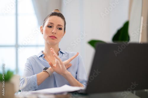 Young business woman finishing the video call with close gesture