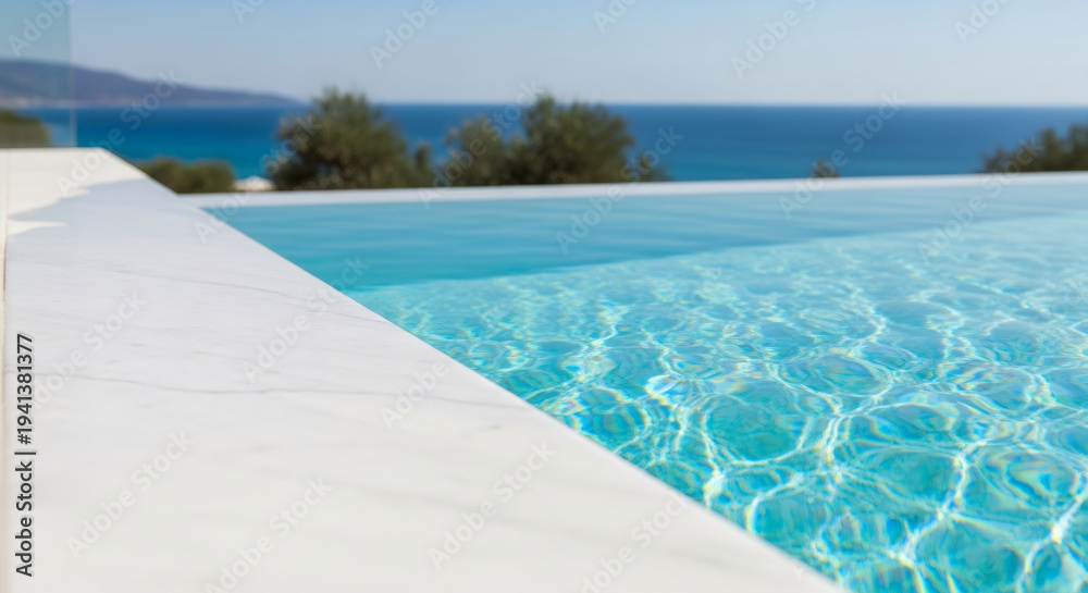 Fototapeta premium Infinity edge swimming pool with shimmering blue water and mediterranean sea view. Luxury summer vacation concept for travel brochure.