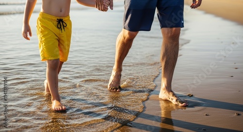 Father and child walking hand in hand on a wet sandy beach at sunset for family background and banner design